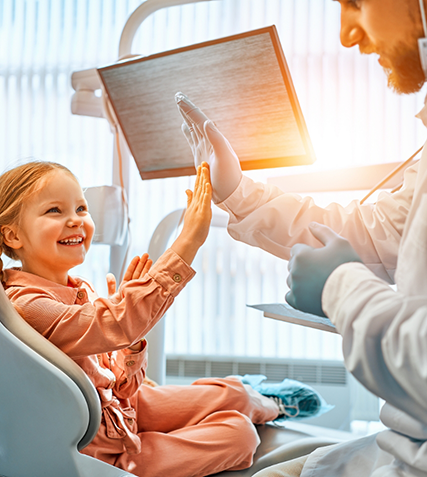 Young girl giving her dentist a high five