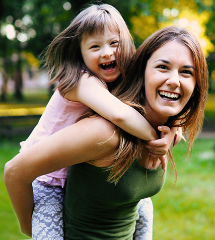 Mother giving her young daughter a piggyback ride