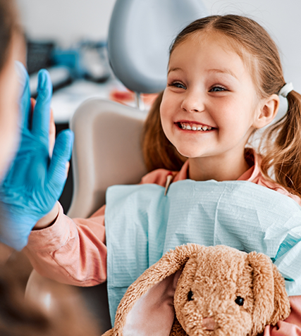 Smiling girl giving her dentist a high five