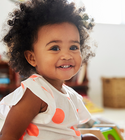 Smiling toddler girl sitting on the floor