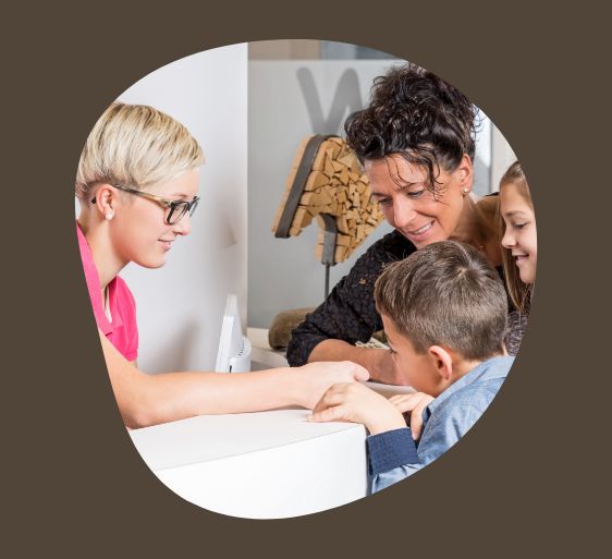 Family of three checking in at front desk of pediatric dental office
