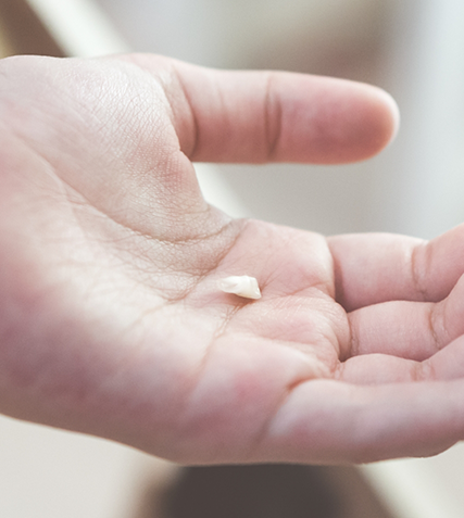 Child holding one of their teeth in their hand