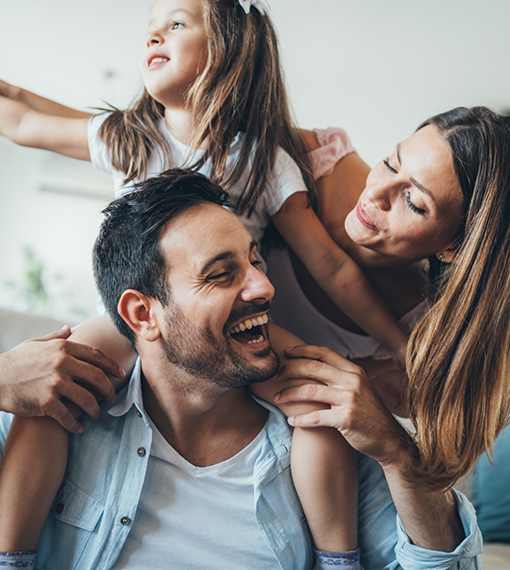 Family of three laughing together after visiting pediatric dentist in Portland