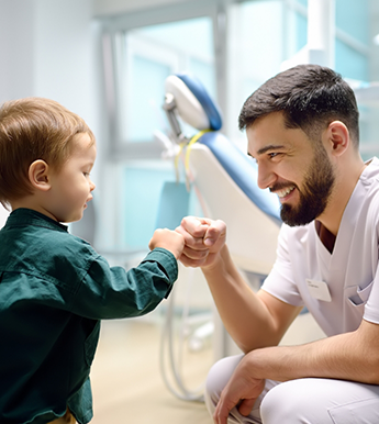 Toddler fist bumping their dentist