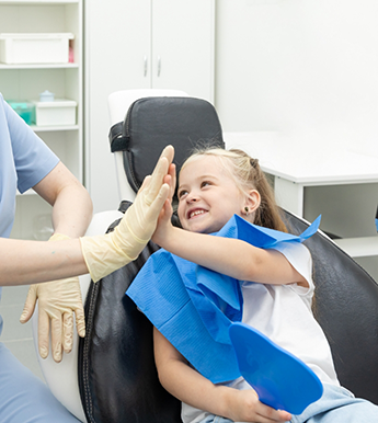 Young girl giving her dentist a high five